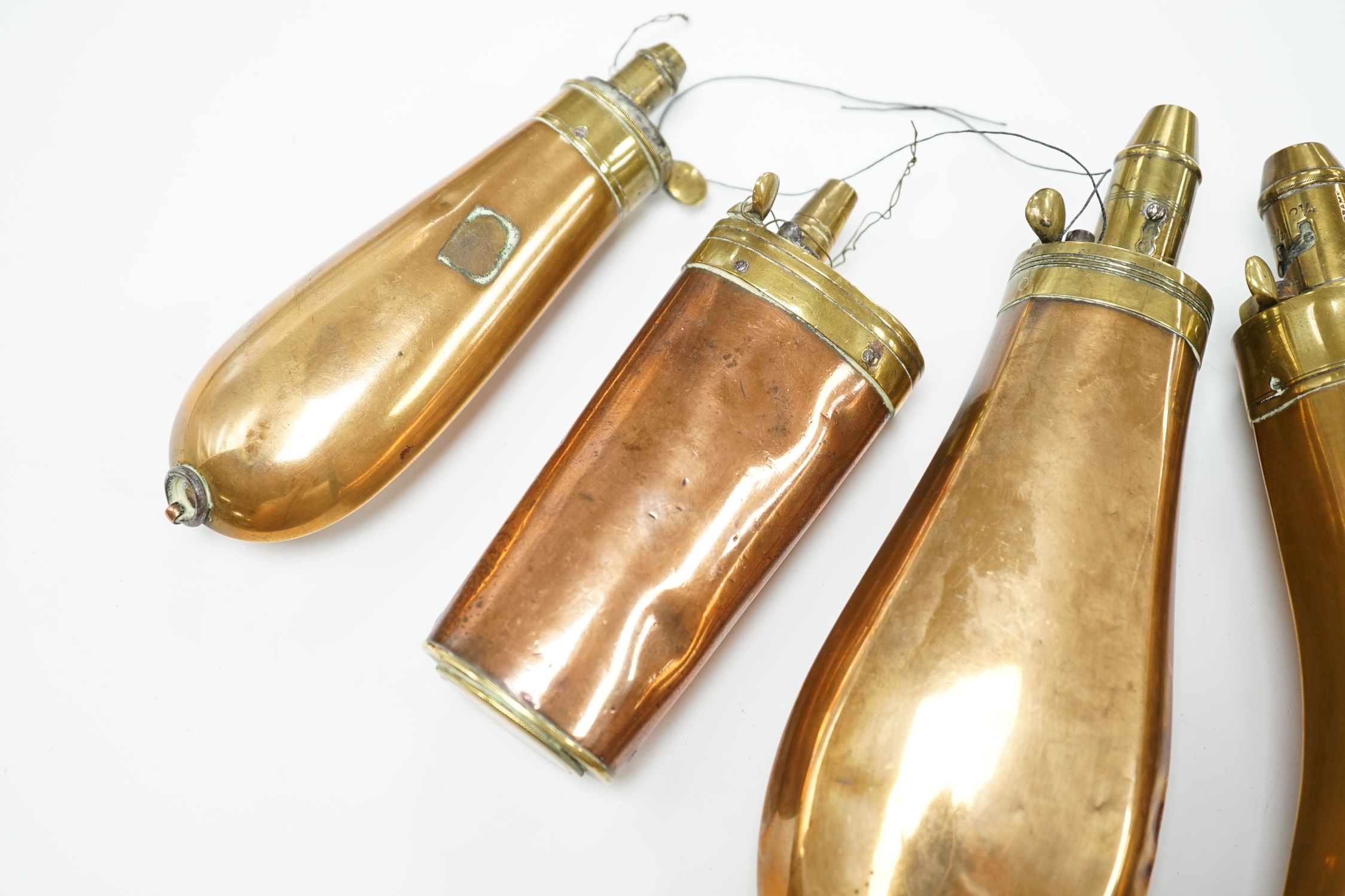 Five 19th century copper and brass powder flasks, all with plain copper bodies. Condition - fair